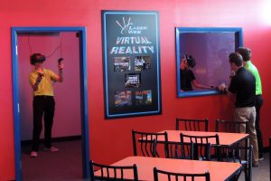 2 Players doing the Virtual Reality attraction, and a shot of the viewing area.